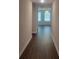 Inviting hallway with wood flooring leads to a bright room with large windows and a ceiling fan at 558 Fairview Oak Place, Dallas, GA 30157