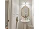 Stylish bathroom featuring a pedestal sink with gold-trimmed mirror, and modern fixtures for a touch of elegance at 6 Sentry Rdg, Dallas, GA 30157