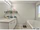 Bathroom showcasing a white vanity, tub, and shelves for toiletries, complemented by natural light at 6 Sentry Rdg, Dallas, GA 30157