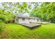 Backyard featuring green grass, concrete slab patio, wooden deck, and trees at 110 Valley View Ct, Tyrone, GA 30290