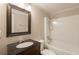 Bathroom featuring dark vanity, a bathtub and shower combo, and a framed mirror at 110 Valley View Ct, Tyrone, GA 30290