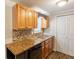 Efficient kitchen design with wood cabinets, granite counters, and tiled backsplash at 110 Valley View Ct, Tyrone, GA 30290