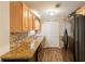 Functional kitchen featuring warm wood cabinetry, granite countertops, and modern black appliances at 110 Valley View Ct, Tyrone, GA 30290