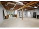 Spacious basement with exposed wooden beams, concrete floor, and natural light at 123 Heritage Pointe, Woodstock, GA 30189