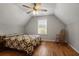 Attic bedroom features a ceiling fan and quilt bedding, creating a cozy space for relaxation and comfort at 123 Heritage Pointe, Woodstock, GA 30189