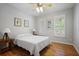Bright bedroom featuring hardwood floors, a ceiling fan, shutters, and neutral colors at 123 Heritage Pointe, Woodstock, GA 30189