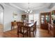 Bright dining room featuring hardwood floors, a chandelier, and natural light from shuttered windows at 123 Heritage Pointe, Woodstock, GA 30189
