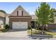 Charming two-story home with brick facade, a two-car garage, and landscaped front yard at 123 Heritage Pointe, Woodstock, GA 30189