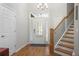 Bright and spacious foyer with hardwood floors, a staircase, and a modern chandelier, offering a grand entrance to the home at 123 Heritage Pointe, Woodstock, GA 30189