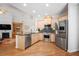 Well-appointed kitchen with stainless steel appliances, a granite-topped island, hardwood floors, and plenty of natural light at 123 Heritage Pointe, Woodstock, GA 30189