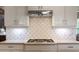 Contemporary kitchen featuring a gas range with stylish backsplash and ample counter space at 2823 Seagrave Way, Marietta, GA 30066