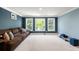 Spacious living room with a comfortable couch, three windows, and modern lighting at 2823 Seagrave Way, Marietta, GA 30066