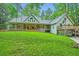 Backyard view of a charming home with a large deck and lush lawn with a tree swing at 2010 Univeter Rd, Canton, GA 30115