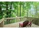 A relaxing back deck overlooking a lush green forest offers a tranquil space for outdoor enjoyment at 2620 Nesbitt Crossing Way, Duluth, GA 30096