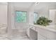 Bright bathroom with a soaking tub under a window and double sink vanity at 2620 Nesbitt Crossing Way, Duluth, GA 30096