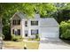 Charming two-story home with a brick facade, light gray siding, well-manicured lawn and mature trees at 2620 Nesbitt Crossing Way, Duluth, GA 30096