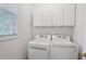 Functional laundry room with washer, dryer, and storage cabinets at 2620 Nesbitt Crossing Way, Duluth, GA 30096