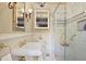 A luxurious bathroom featuring gold fixtures, marble floors, a glass shower, and a built-in cabinet at 452 Cherokee Ne St, Marietta, GA 30060