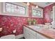 This bathroom features red floral wallpaper, stained glass windows, and a sink with white cabinetry and tile countertops at 452 Cherokee Ne St, Marietta, GA 30060