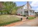Inviting two-story home with a screened-in porch, complemented by lush landscaping and a brick walkway at 452 Cherokee Ne St, Marietta, GA 30060