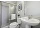 Bathroom featuring a glass shower, pedestal sink and toilet with flower arrangement at 6442 Canopy Dr, Sandy Springs, GA 30328