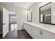 Bright bathroom featuring double sinks, a large mirror, white cabinets, and a tiled floor at 6442 Canopy Dr, Sandy Springs, GA 30328