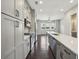 Modern kitchen with gray cabinets, stainless steel appliances, and quartz countertops open to living area at 6442 Canopy Dr, Sandy Springs, GA 30328