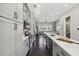 Modern kitchen with gray cabinets, stainless steel appliances, and quartz countertops open to living area at 6442 Canopy Dr, Sandy Springs, GA 30328