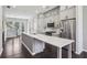 Spacious kitchen features gray cabinets, stainless appliances, and a central island with marble countertop at 6442 Canopy Dr, Sandy Springs, GA 30328
