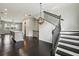 Bright open-concept living area featuring dark hardwood floors, stairs, and modern light fixtures at 6442 Canopy Dr, Sandy Springs, GA 30328