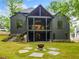 Expansive backyard featuring a fire pit with stone pavers, a covered patio, and lush landscaping at 0 Chattahoochee St, Roswell, GA 30075