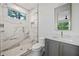 Bright bathroom showcasing a glass-enclosed shower with marble-style tile, complemented by a gray vanity and mirror at 0 Chattahoochee St, Roswell, GA 30075