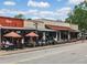 Vibrant outdoor dining scene with umbrellas, tables, and patrons enjoying the lively atmosphere at 0 Chattahoochee St, Roswell, GA 30075