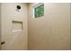 Close-up of the shower featuring textured tiling, recessed niche, sleek fixtures, and a window at 0 Chattahoochee St, Roswell, GA 30075