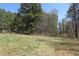 Lush green grass on this wooded lot leading to the road, showing off the property's picturesque landscaping at 8740 Atlanta Newnan Rd, Chattahoochee Hills, GA 30268