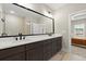 Stylish bathroom with dual sinks, brown cabinets, black fixtures, and an open view to the main bedroom at 1434 Fairmont Ave, Atlanta, GA 30318