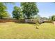 Backyard featuring a spacious lawn, mature trees, and a wooden privacy fence at 1045 Ridgecrest Se Dr, Smyrna, GA 30080