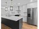 Modern kitchen boasts stainless appliances, quartz counters, and designer light fixtures over a large island at 1045 Ridgecrest Se Dr, Smyrna, GA 30080