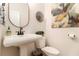 Elegant powder room boasts a pedestal sink, decorative mirror, modern wall art, and stylish fixtures at 1976 Cobblestone Ne Cir, Atlanta, GA 30319