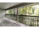 View from covered balcony with wooden floor and railings overlooking lush trees and foliage at 2901 Ne Lenox Rd # 305, Atlanta, GA 30324