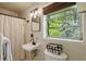 A cozy bathroom features a decorative mirror, natural lighting, and a white shower curtain at 2029 Dover Hill Ne Pl, Atlanta, GA 30345