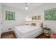 Bright bedroom featuring hardwood floors, two windows, a ceiling fan, and contemporary decor at 2029 Dover Hill Ne Pl, Atlanta, GA 30345
