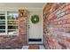 Close-up of a brick home's front door with a wreath and sidelight window, creating a warm welcome at 2029 Dover Hill Ne Pl, Atlanta, GA 30345