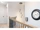 Hallway featuring a decorative chandelier, black wrought iron railing, and neutral paint at 475 Mcdonough Rd, Fayetteville, GA 30214