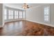 Spacious bedroom features gleaming hardwood floors and large windows with wood blinds at 621 Champions Dr, Mcdonough, GA 30253