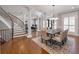 Open-concept dining room with a stylish chandelier, hardwood floors, and large windows at 621 Champions Dr, Mcdonough, GA 30253