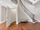 Elegant foyer featuring a curved staircase with iron balusters and hardwood floors with a small ottoman at 621 Champions Dr, Mcdonough, GA 30253