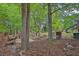 Wooded backyard with built-in benches and a designated fire pit area for outdoor gatherings at 191 Gates Mill Dr, Lawrenceville, GA 30045