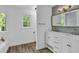 Bright bathroom featuring double vanity, modern fixtures, stylish wall decor, and wood flooring at 191 Gates Mill Dr, Lawrenceville, GA 30045