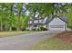 Beautiful white home with a large driveway and lush green trees surrounding the property at 191 Gates Mill Dr, Lawrenceville, GA 30045